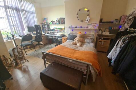 A cozy single bedroom featuring a comfortable b...