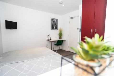 Bright, simply furnished bedroom with a comfort...