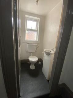 Compact single toilet room featuring a frosted ...