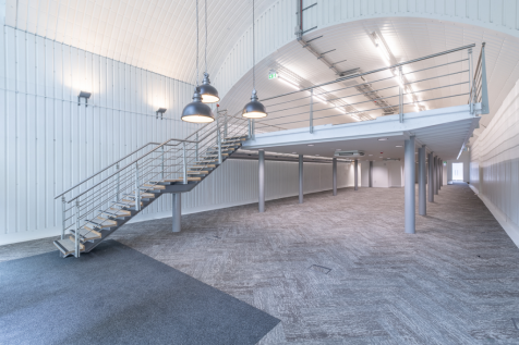 The mezzanine level of an arch, with carpet and lined white.