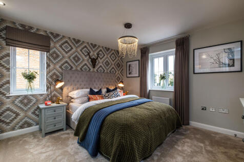 A dual aspect double bedroom with patterned wallpaper