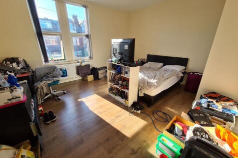 A bright double bedroom featuring a large windo...