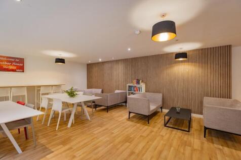 Modern communal lounge with light wood flooring...