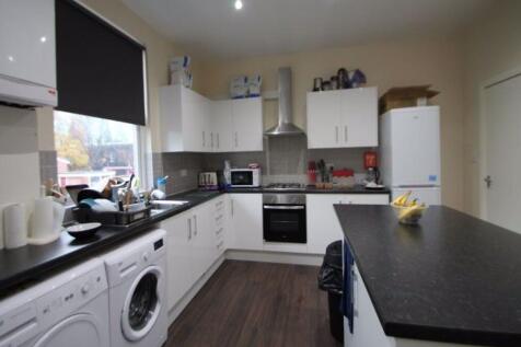 A modern kitchen featuring white cabinetry with...