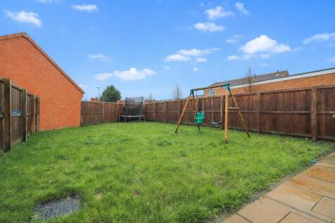 Suburban backyard with swing set and trampoline.jp