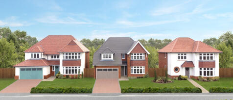 Three modern detached houses with front gardens and driveways, set against a green wooded background