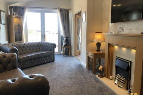 Spacious Lounge With Leather Sofas And Fireplace