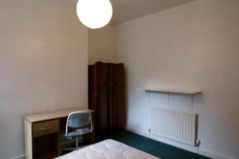 Simple, neutrally painted bedroom with a mattre...