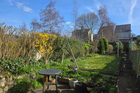 Long, private garden with patio and mature planting