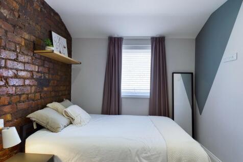 A bright, well-maintained bedroom with a stylis...