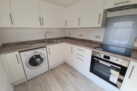 A modern kitchen with clean white cabinets, a w...