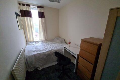 Cozy single bedroom featuring a comfortable bed...