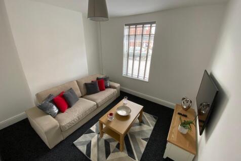 Bright, neatly furnished living room with a com...