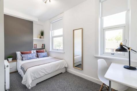 Bright and spacious master bedroom with large w...