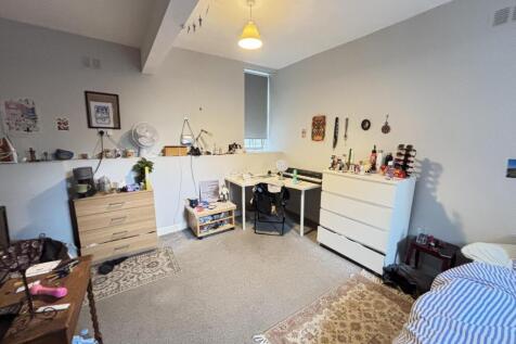 A cozy bedroom featuring a double bed with a sm...