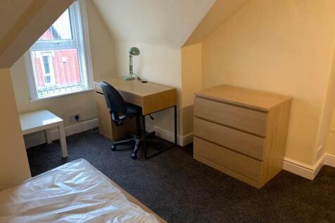 A bright and tidy single bedroom featuring a de...