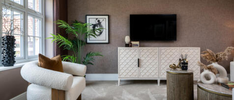 Modern living room with a cream textured armchair, potted plant, wall art, TV, and stylish decor in