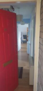 Welcoming entrance hallway with a bright red fr...