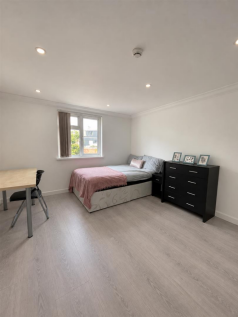 Bright Minimalist Bedroom with Desk and Dresser.pn