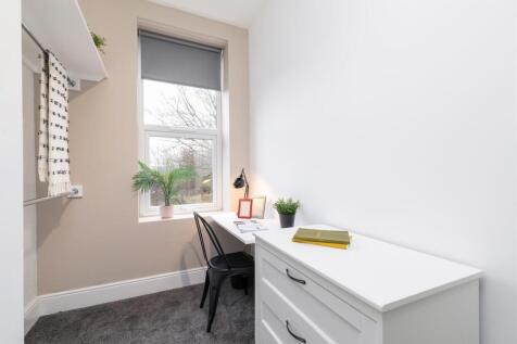 Bright, neatly presented bedroom with a study s...