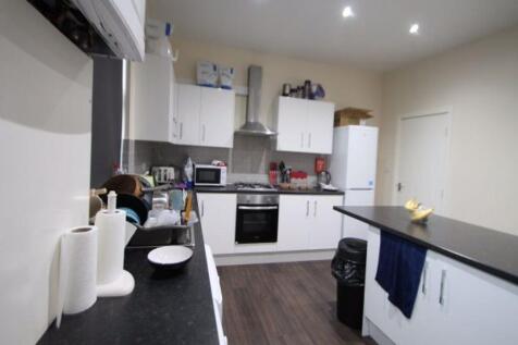 A modern kitchen featuring sleek white cabinets...
