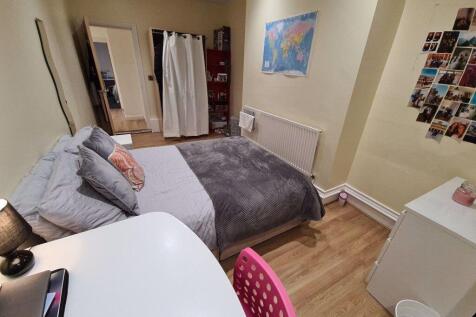 A bright and tidy bedroom with a comfortable do...