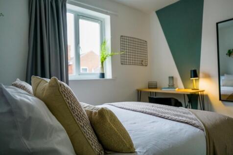 A spacious and well-lit master bedroom featurin...