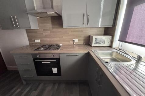 A modern kitchen with grey cabinets and a woode...