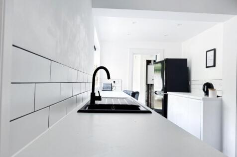 Bright, modern galley-style kitchen with white ...