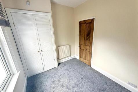 Bright bedroom with plush carpet and wardrobe...
