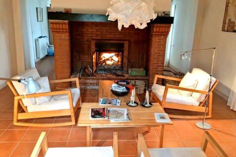 A cozy living room featuring a lit fireplace, surr