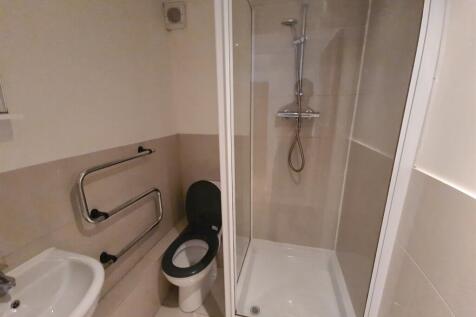 A clean, modern bathroom featuring a shower enc...