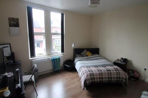 A bright double bedroom featuring a large windo...
