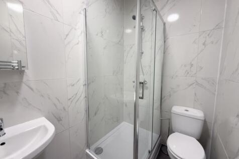 Modern bathroom with a corner glass shower encl...
