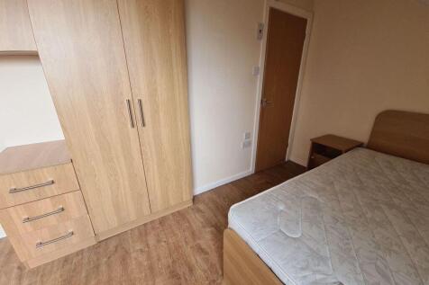 A cozy bedroom featuring a double bed, a fitted...