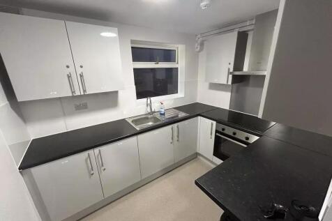 Modern U-shaped kitchen with sleek black counte...