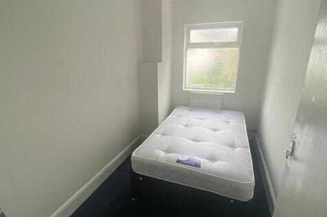 A compact single bedroom featuring a fresh, whi...