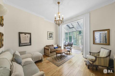 A raised ground floor flat with high ceilings, period features, and wooden flooring throughout. The property offers two large double bedrooms with fitted storage, a bright reception room leading to a