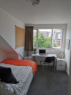 Bright, tidy bedroom with a large window overlo...