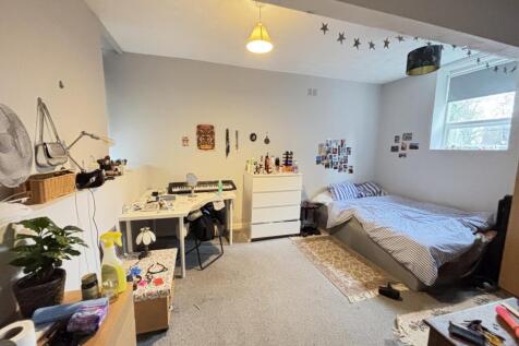 A well-lit, inviting bedroom featuring a comfor...