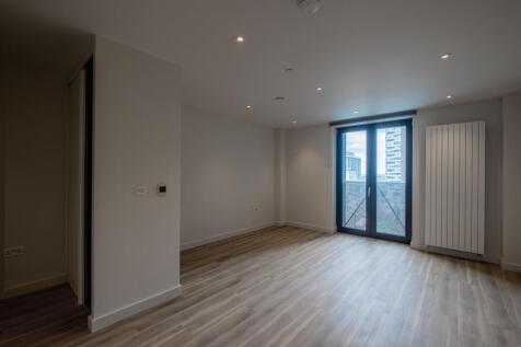 Experience urban living with this spacious room, featuring expansive glass doors and stylish wooden floors.