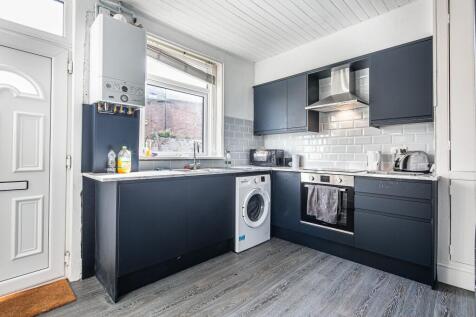 Modern galley-style kitchen with dark flat-fron...