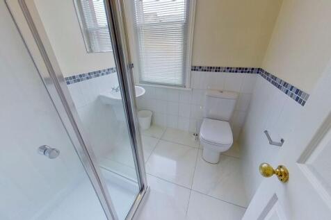 Bright, modern bathroom with a tiled shower enc...