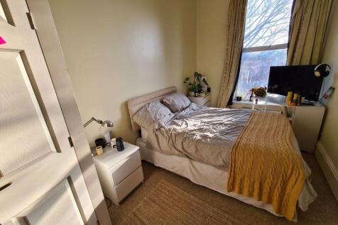 A bright and welcoming master bedroom featuring...