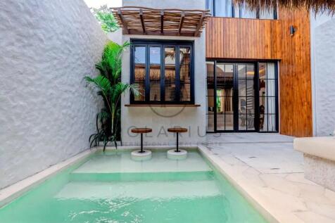 A small, modern courtyard with a turquoise swimmin