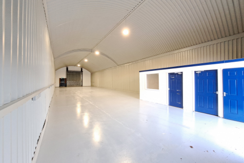 An empty arch with white lining and a WC cubicle to the front.