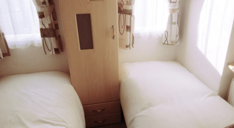 Twin Bedroom With Storage Unit And Bright Windows