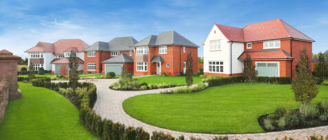 Modern detached houses with red and white brick exteriors and well-maintained gardens at Kings Moat