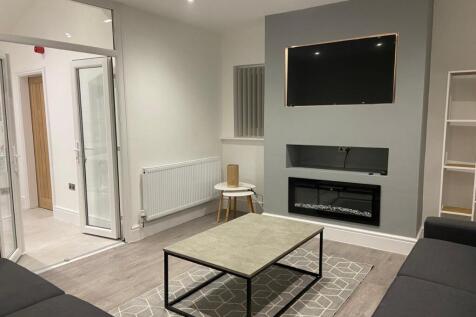 Contemporary living room with wall-mounted TV a...