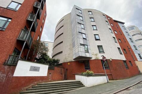 This spacious one-bedroom apartment in Manchester's Northern Quarter offers a bright living room, a modern kitchen, a large furnished bedroom, and a sleek bathroom with a shower over the bath—all in a